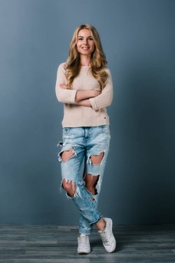 Sırdaş ve neşeli. Güzel genç kadının gülümseme duran siyah arka plan ile kameraya bakarak tam uzunlukta