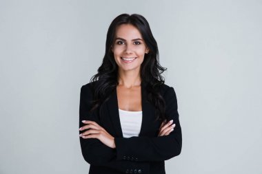Mükemmel iş kadını. Güzel genç işkadını gülümseme duran beyaz arka plan ile kameraya bakıyor