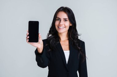 Bu app gördün mü? Onun smartphone gösterilen ve gülümseme duran beyaz arka plan ile kameraya bakarak güzel genç iş kadını