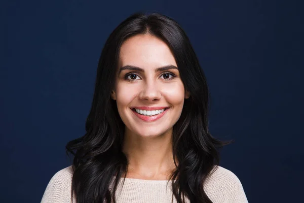 Saf güzellik. Siyah arka plan karşı dururken gülümseme ile kameraya bakıyor güzel genç kadın portresi