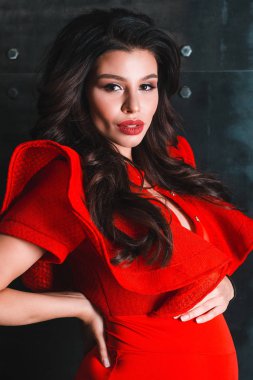 Sadece kırmızı. Güzel genç hamile kadın onun bebek carpma beton arka plan karşı dururken dokunmadan