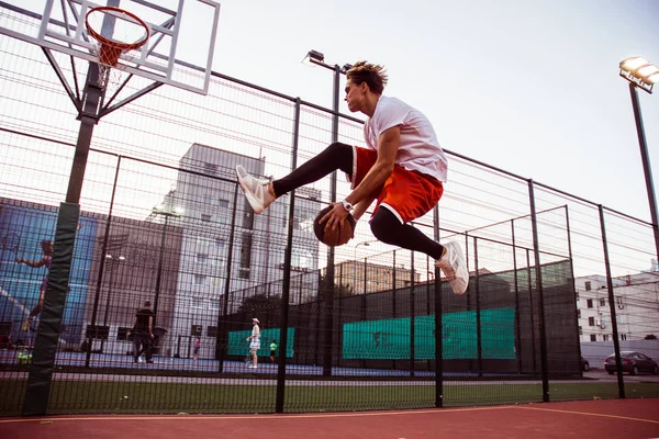 Atla! Basketbol basketbol sahasına açık havada spor genç adam tam uzunlukta