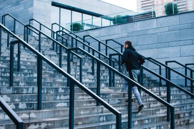 Sadece yukarı! Merdiven sanayi kenti görünümü karşı koşu spor genç adam tam uzunlukta
