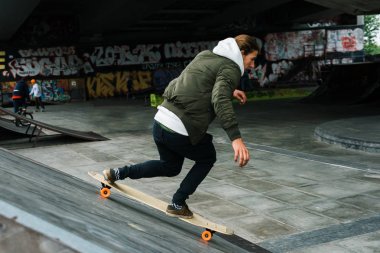 Longboarding hareket. Yakışıklı genç longboarding ve uzak kaykay parkı açık havada gülümseme arıyorsunuz 
