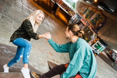 Sana öğretebilirim. Kaykay Parkı açık havada gülümseme genç yakışıklı erkek arkadaşlarını tutan el