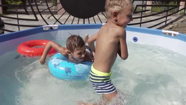 Дети веселятся, играя в воде и плавая — стоковое видео