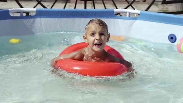 Il ragazzo galleggia su una piscina gonfiabile in piscina — Video Stock