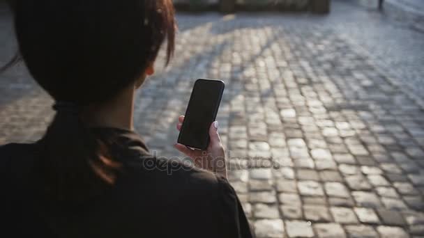 Молодая деловая женщина в очках проходит по городу с документами и беседами по телефону — стоковое видео