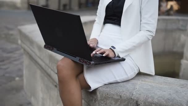 Młoda kobieta w okulary pracy na komputerze w mieście — Wideo stockowe
