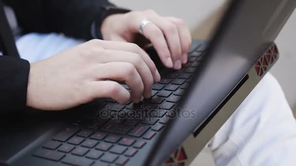 Een jonge man in de open lucht werkt op een computer — Stockvideo