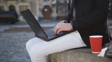 Şehir ve içecekler kahve alanındaki bir bilgisayarda gözlük çalışmalarında bir genç iş adamı