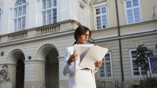 A young business woman goes to the city and looks at the documents — Stock Video