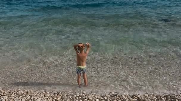 Pojken står vid stranden av Adriatiska havet och fascineras av naturens skönhet — Stockvideo