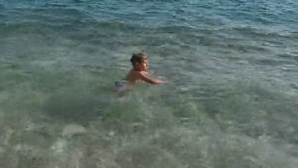 Kleine jongen duikt in de Adriatische Zee. Golven in de zee. Kroatië — Stockvideo