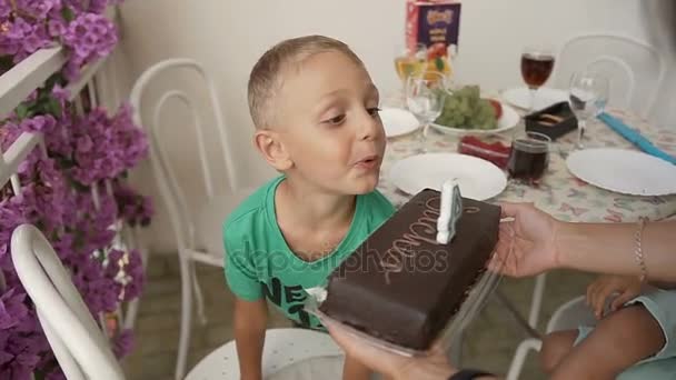 Bolo de chocolate no aniversário de um menino. O aniversário de crianças, acendemos uma vela em um bolo. Bespoke infância, um aniversário, felicidade. Quatro anos. — Vídeo de Stock