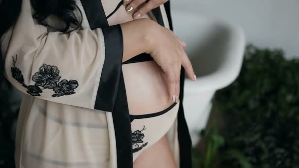 En gravid kvinna i en vacker siden klänning vidrör magen försiktigt. Väntar på ett mirakel — Stockvideo