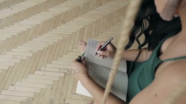 Bir el üstünde boş bir defter bir kalem ile yazılı bir kadının yakın çekim.