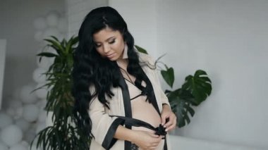 Harika bir kız bir bebek doğum için bekleyen ipek uzun siyah saçlı. Mutlu hamilelik. Bir mucize bekliyorum