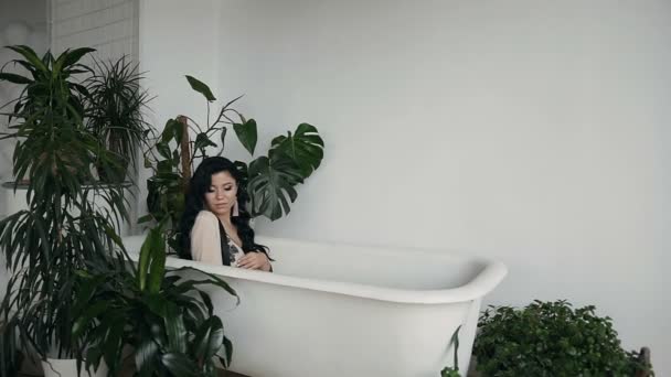 Модное интерьерное видео великолепной беременной женщины с темными волосами в нижнем белье, позирующей в ванной — стоковое видео