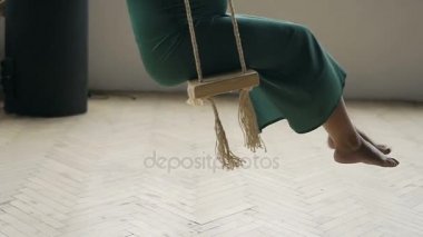 Tahta salıncakta sallanan genç kaygısız pregancy kadın