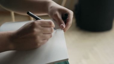 Bir el üstünde boş bir defter bir kalem ile yazılı bir kadının yakın çekim.