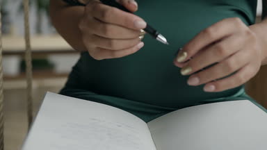 Genç bir kadın bir defter Siyah kalemle bir not yazıyor