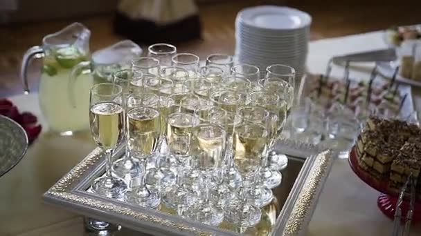 Flute of cold white champagne or sparkling wine standing on the tray at a festive event or celebration — Stock Video