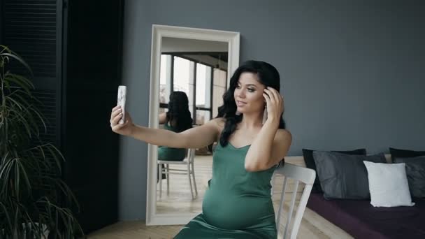 Linda morena fazendo sephi em seu telefone, sorrindo. interior moderno — Vídeo de Stock