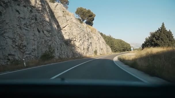 Asfalterad bergsväg med skarp skarp sväng nära klippan. Visa från vindrutan. Köra bil på bergsväg. Naturen Kroatien — Stockvideo