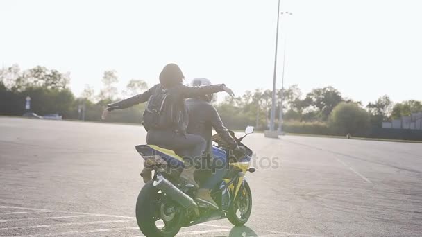 Pareja feliz montando una ciudad de motocicletas al atardecer. Concepto de viaje — Vídeos de Stock