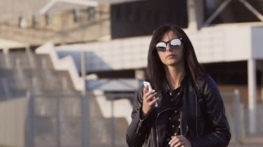 Ofis binası dışında telefonda konuşurken bir güzel, şık iş kadını gülümsüyor