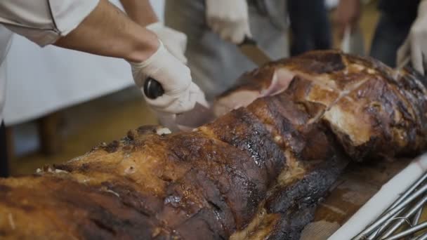 Kokk med kniv og gaffel. Profesjonell kokk på restaurant eller hotell tilbereder eller skjærer opp bakt gris – stockvideo