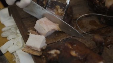 Sulu dilim et pişmiş. Şef bıçak ve çatal ile. Bir restoranda profesyonel şef hazırlar ya da pişmiş domuzu kesme