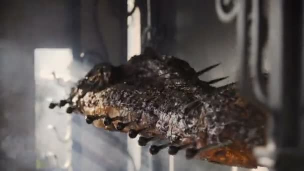 Detail jatečně upravených těl z vepřového masa, který je smažené na rožni. Příprava kostry prase na grilu — Stock video