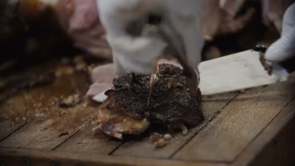 O cozinheiro corta a carne cozida da carcaça do porco. Delicioso porco assado suculento — Vídeo de Stock