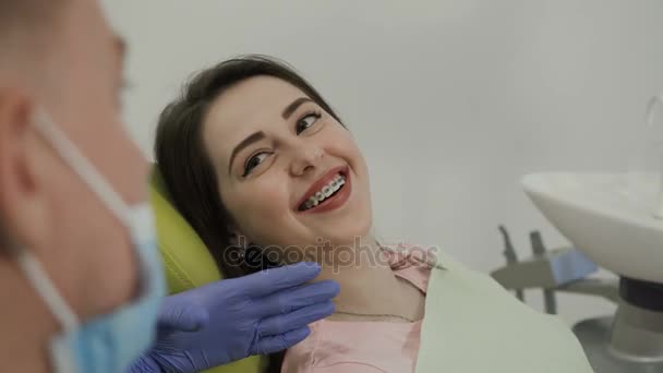 Una mujer sonriendo al dentista. Trabajo del dentista con el paciente. La sonrisa perfecta — Vídeos de Stock