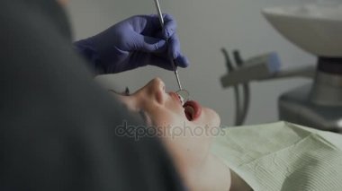 Hastanın sağlıklı dişler. Hasta dişlerini aynada inceleyerek diş hekimi