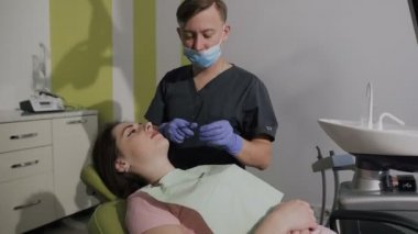 Elastik örgü giyen bir ortodontist. Sağlıklı dişler. Hastanın iyi gülümseme