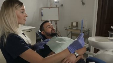 Yakın çekim A diş rozeti bir dişçi elinde. Dişçi Hizmetleri