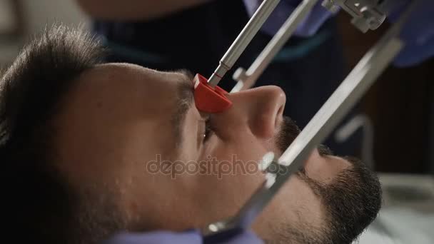 Jonge man bij de benoeming van een tandartsen. Installatie van de gezicht-bow — Stockvideo