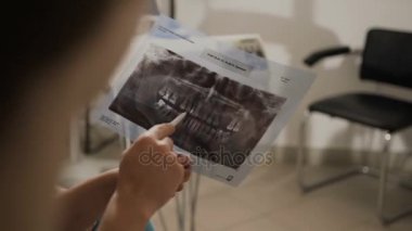 Diş hekimi hastanın röntgeni diş gösterir. Diş hekimleri lycather hastanın durumu onun dişlerini gösterir. Doktor hasta tavsiye eder.