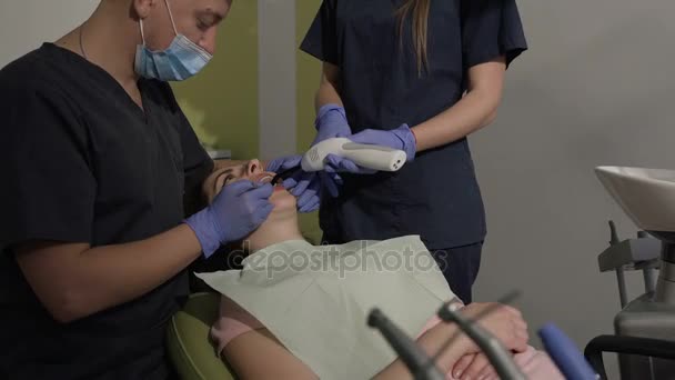 Tandläkaren och hans assistent behandla sina tänder till sin patient. Friska tänder. Tandkliniken — Stockvideo