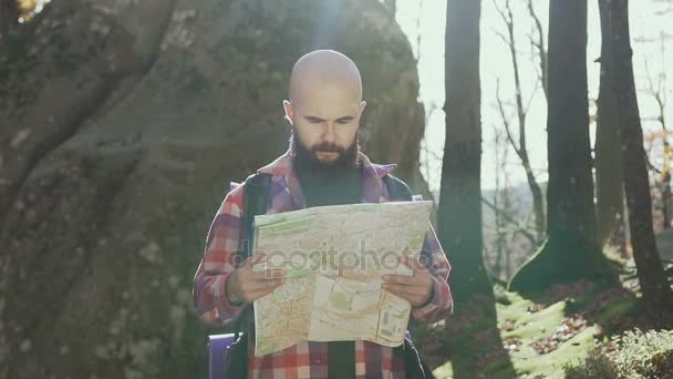 Hipster stylowy człowiek podróżnik z plecaka trzyma mapę i odkrywania na szczycie góry, koncepcja podróży — Wideo stockowe