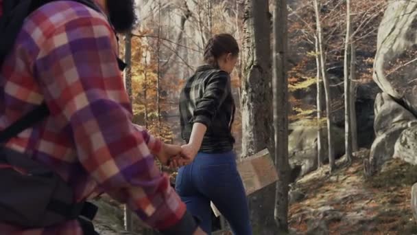 Folgen Sie mir - glückliche junge Frau zieht Jungs Hand in Hand durch den Herbst an einem strahlend sonnigen Tag. Wald und Felsen an einem sonnigen Herbsttag — Stockvideo
