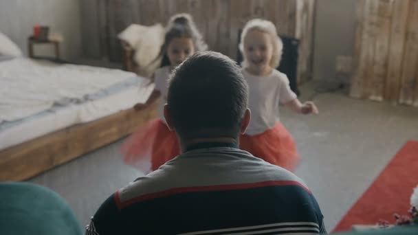 An Heiligabend treffen zwei junge Mädchen glücklich ihren Vater, der Geschenke für sie hält. glückliche Familie. Neues Jahr — Stockvideo