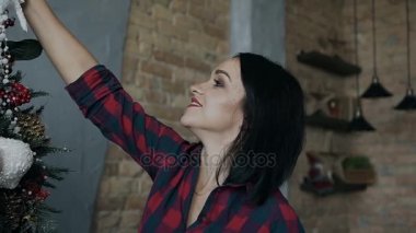 Güzel bir genç anne dekorasyon dekoratif bir Noel ağacı Noel close-up. Yılbaşı ağacı süsleri