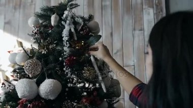 Oldukça genç bir kızın dekorasyon dekoratif bir Noel ağacı Noel yakın çekim. Yılbaşı ağacı süsleri