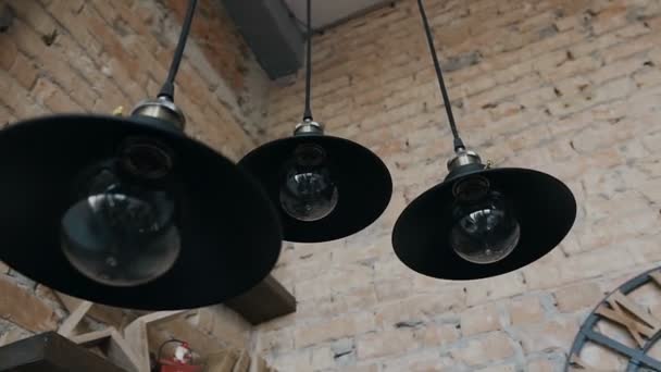 Цегляна стіна і три темні стельові лампи — стокове відео