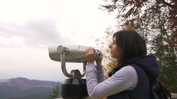 Une fille qui regarde l'horizon. Jeune fille hipster avec sac à dos sombre regardant sur la plate-forme d'observation. Vue latérale de voyageur touriste femme qui regarde des jumelles sur les montagnes, jumelles à pièces de monnaie — Video