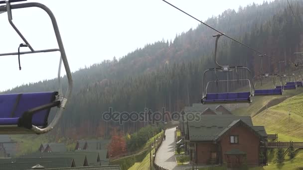 Niski kąt strzału wyciągu narciarskiego ośrodka narciarskiego Bukovel w górach w słoneczny dzień jesieni. Błękitne niebo, słońce i Las na tle lato jazda natura top sport ekstremalny rekreacja koncepcji w — Wideo stockowe